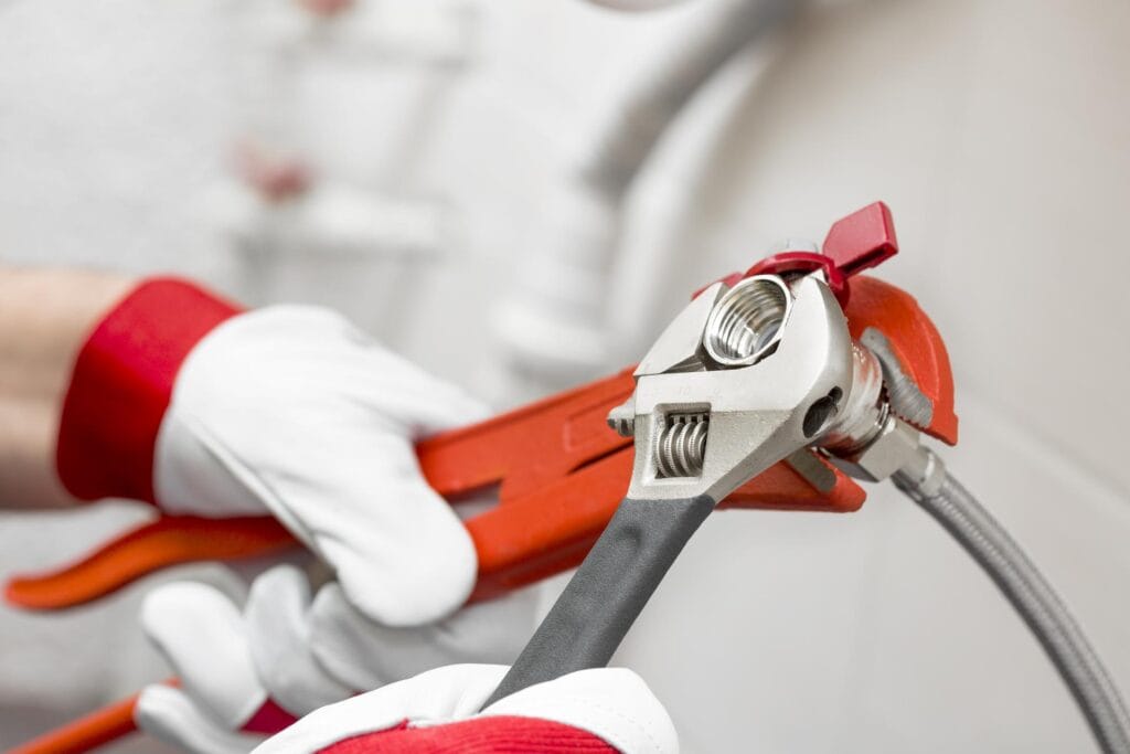 Plumber holding pipe wrenches for an emergency repair in Murrieta