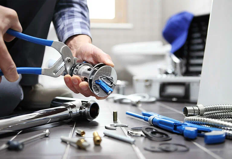 Technician repairing a plumbing fixture with professional tools in Murrieta