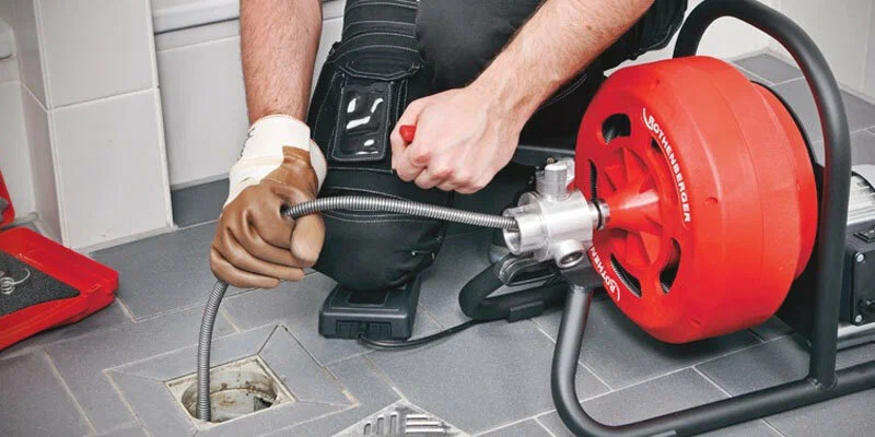 Plumber using a drain-cleaning machine in Murrieta