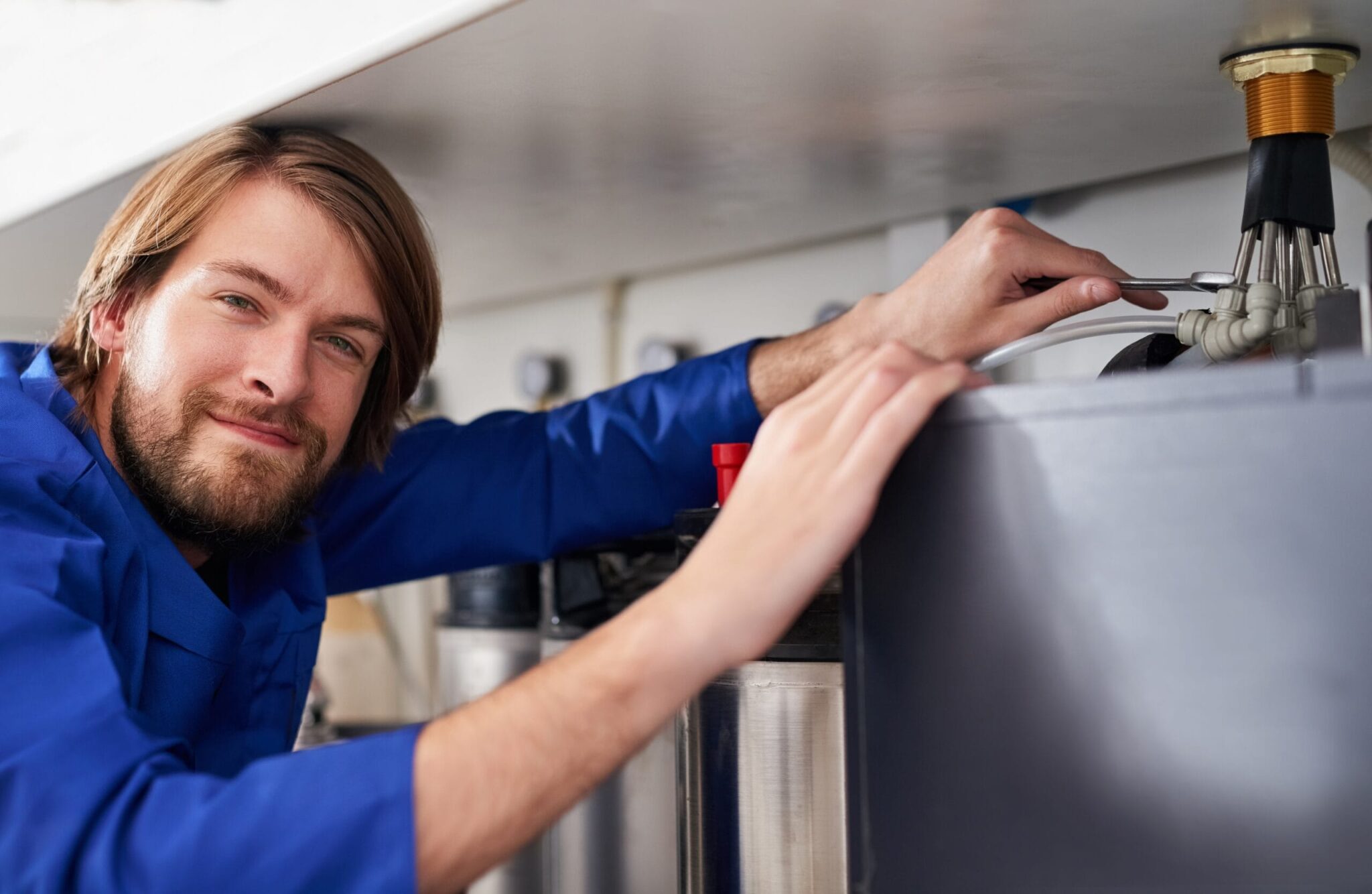 Technician servicing a residential water heater tank in Murrieta